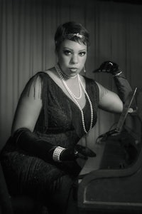 a black and white photo of a woman sitting at a piano