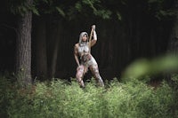 a woman in the woods holding a bat