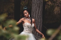 a black woman in a white dress in the woods